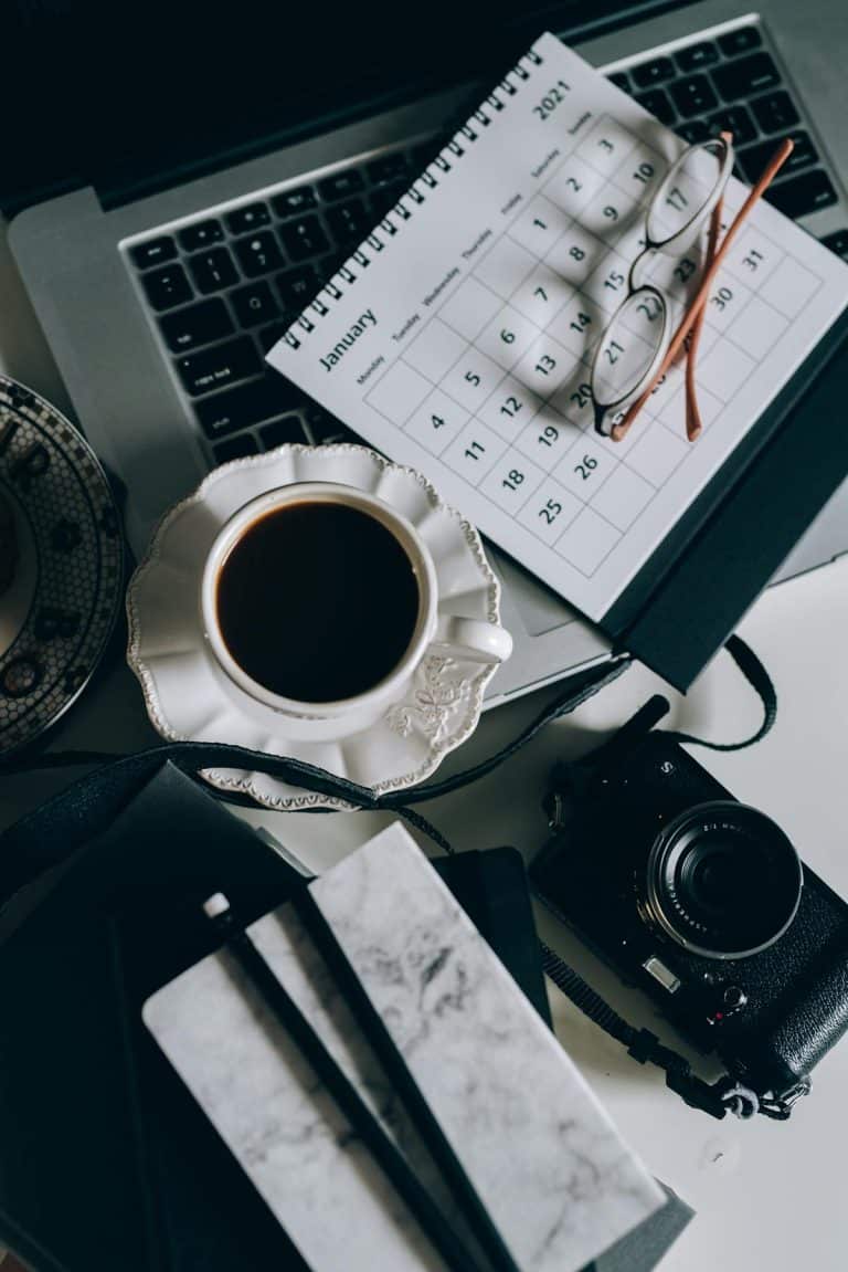 Calendrier, agenda et café sur un bureau — organiser le plan d'action après un diagnostic TDAH ou TSA