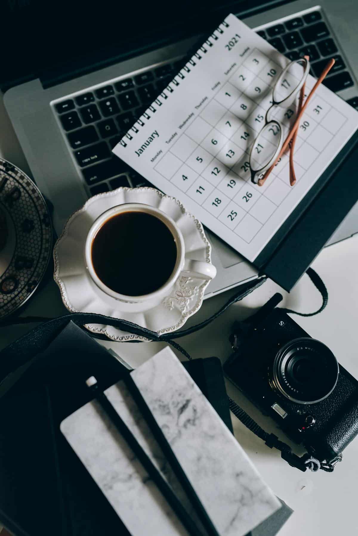 Calendrier, agenda et café sur un bureau — organiser le plan d'action après un diagnostic TDAH ou TSA